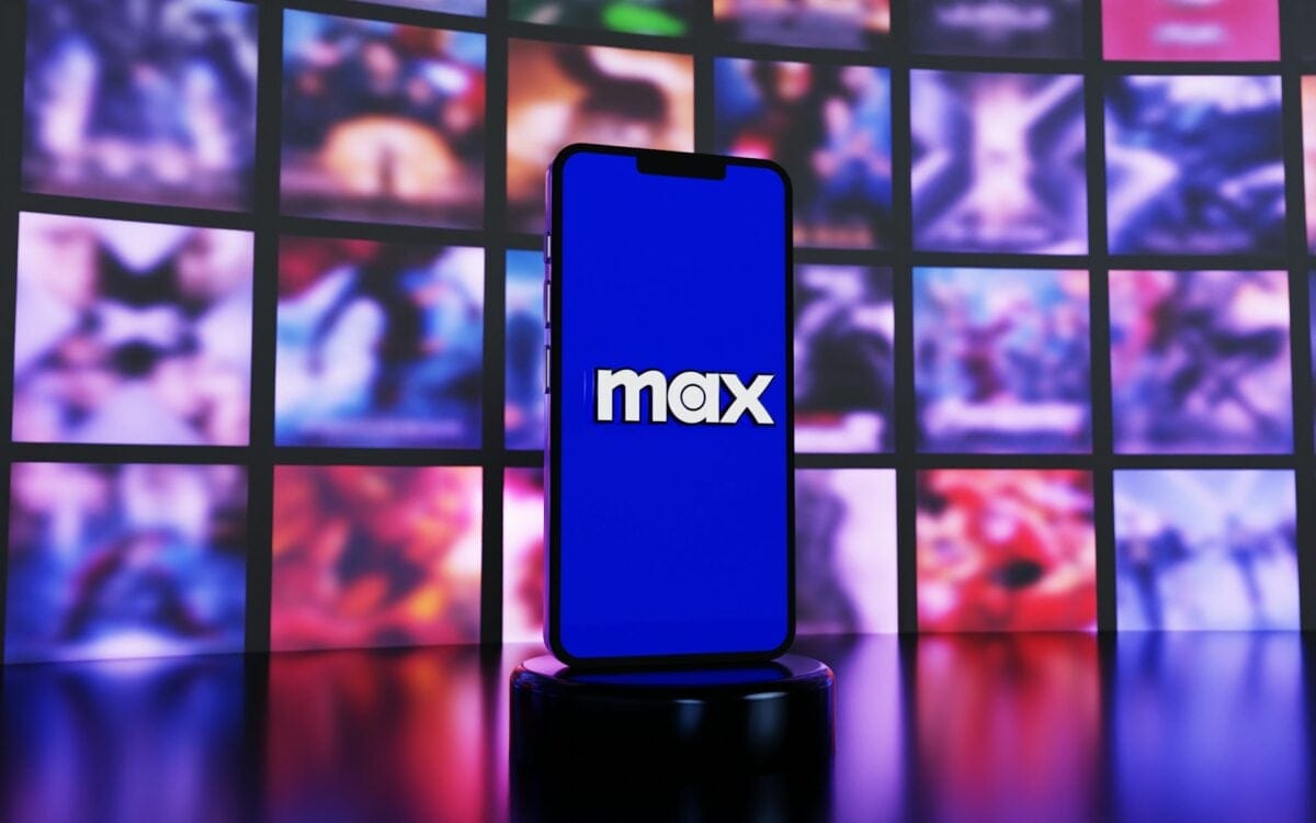 hbo max logo on phone in front of screens